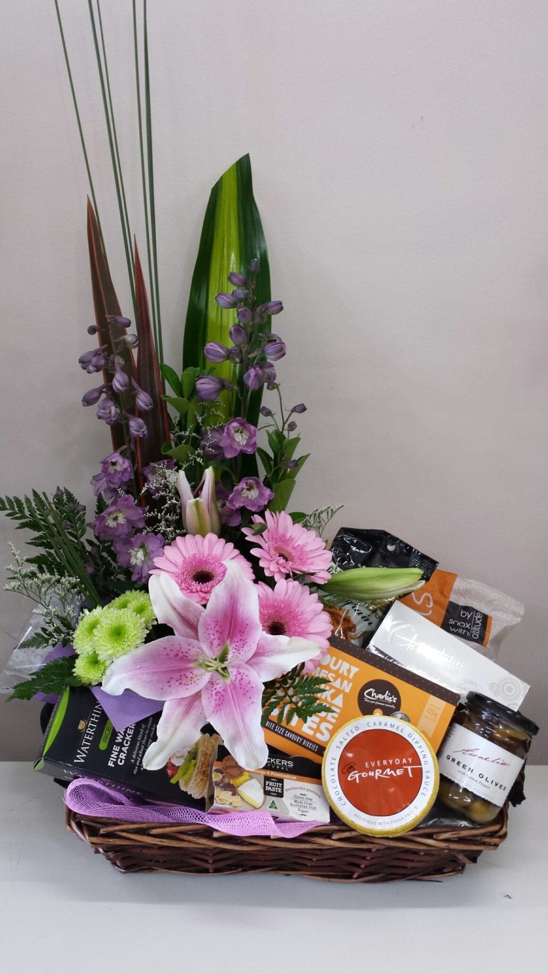 Selection of gourmet products with flower arrangement on one side