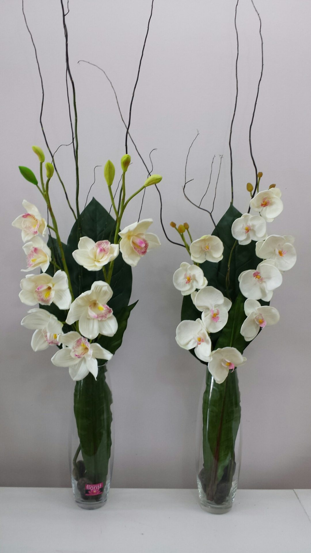 Tall glass vases with Orchids and willow sticks