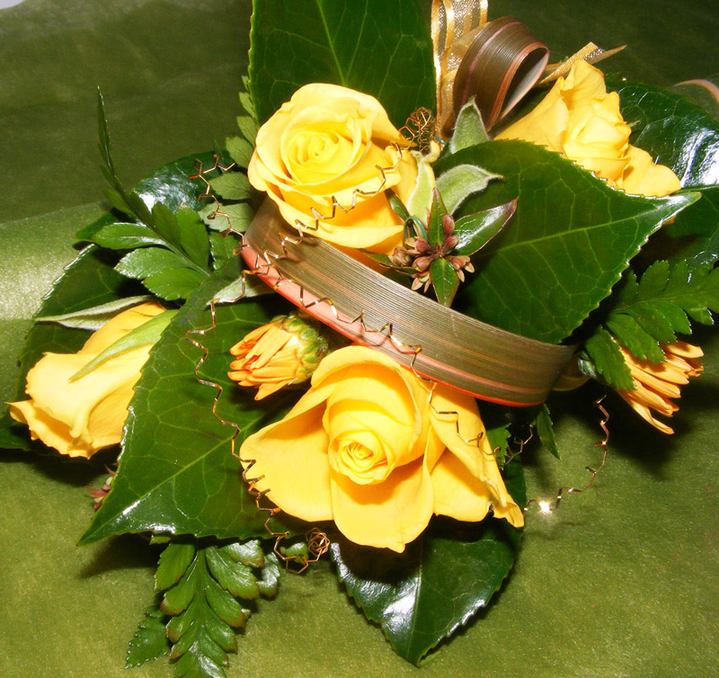Wrist style corsage with gold roses and loops of flax