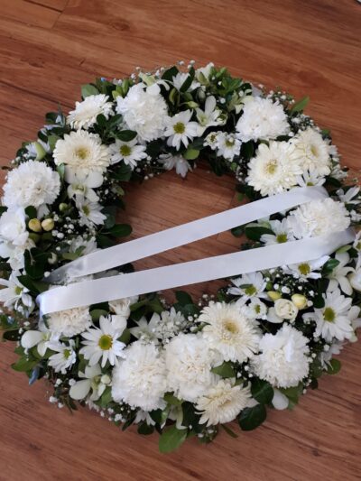white mixed flower wreath with ribbon